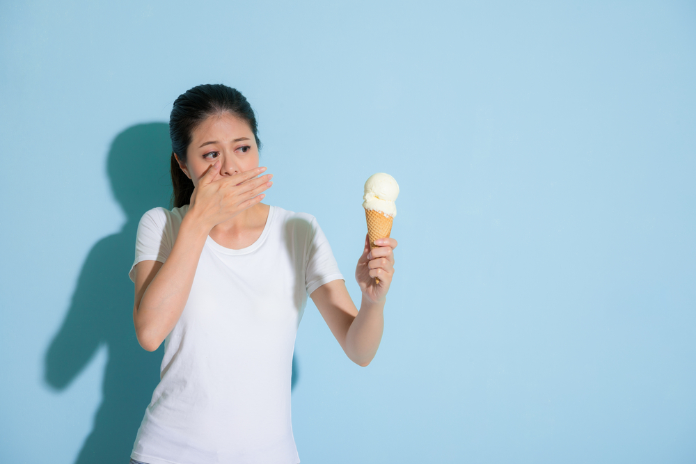 Pretty,Sweet,Girl,Eating,Ice,Cream,And,Hand,Cover,Mouth