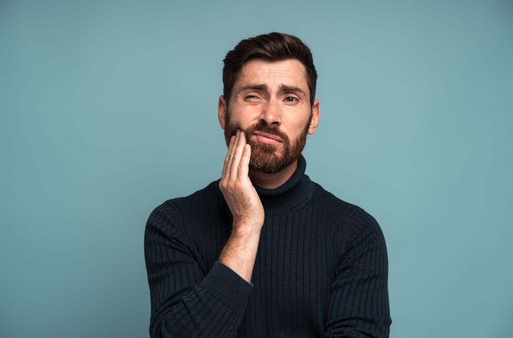 Dental,Problems.,Portrait,Of,Unhealthy,Man,Pressing,Sore,Cheek,,Suffering