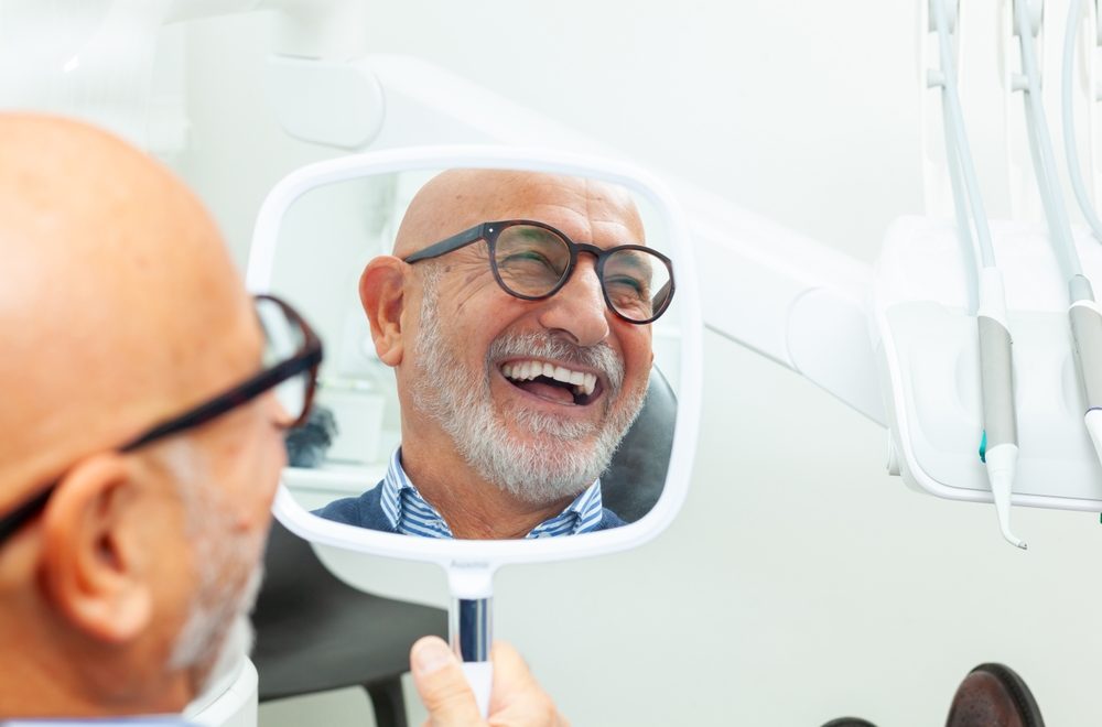 Happy,Senior,Patient,Admiring,His,Perfect,Smile,After,A,Dental